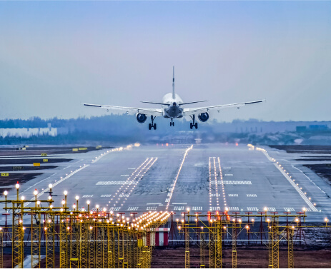 Photo showing a rear vantage point of a commercial airplane lifting off a runway to take flight.