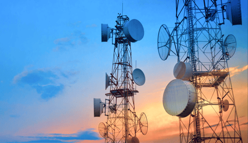 Graphic with blue tint showcasing telecommunication structures at sunset