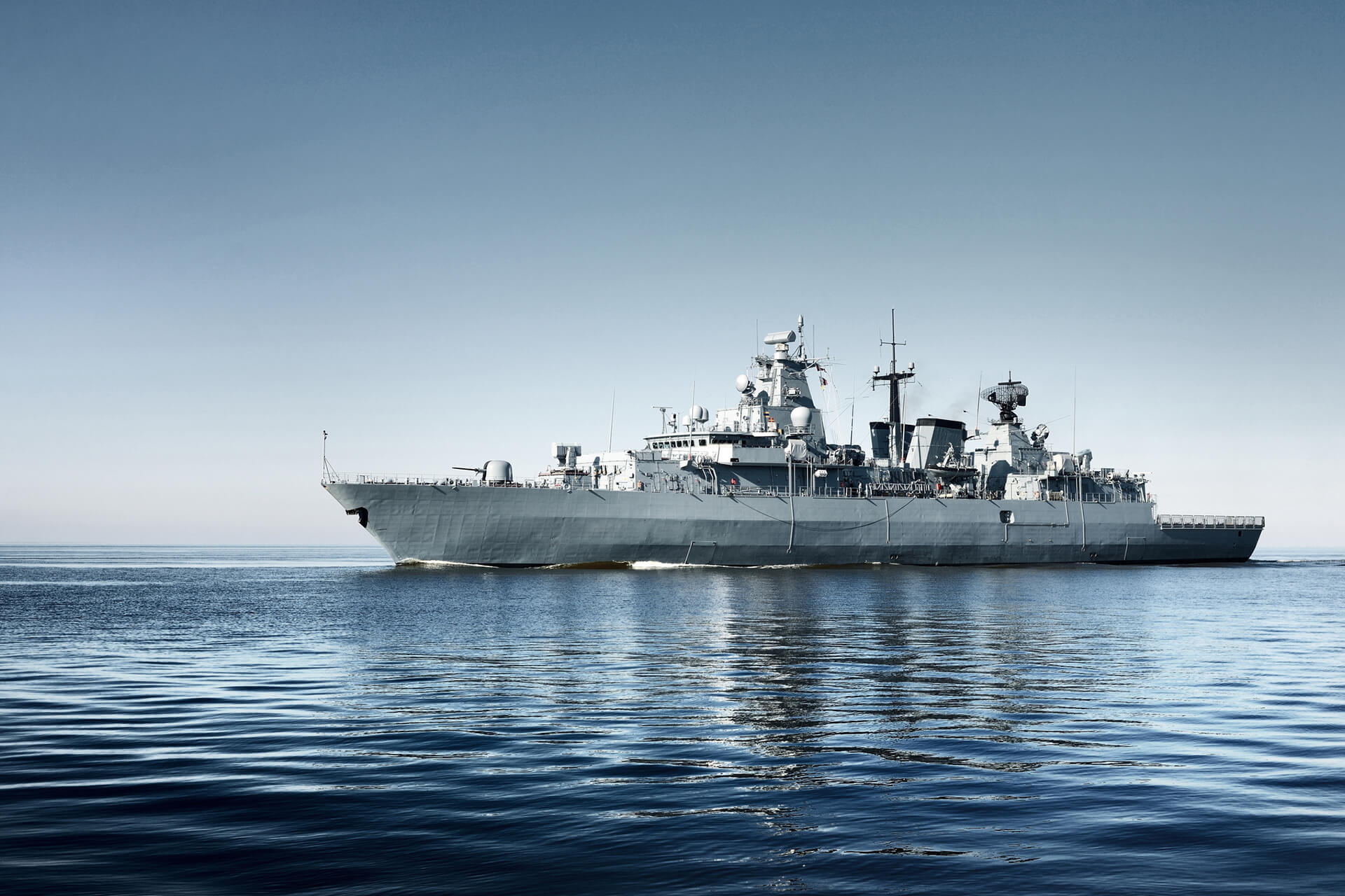 Slider showcasing a gray Military ship in the ocean in the afternoon