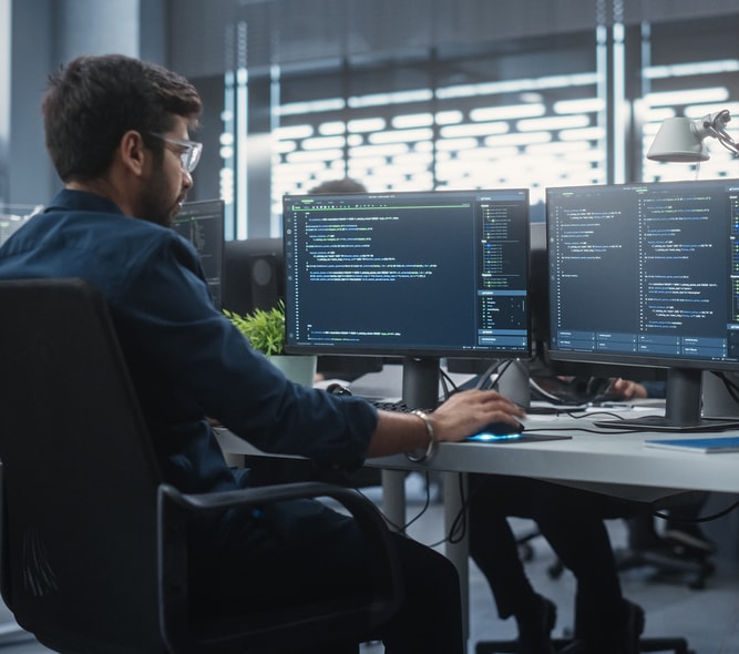 Developer working in an open office environment with other developers.