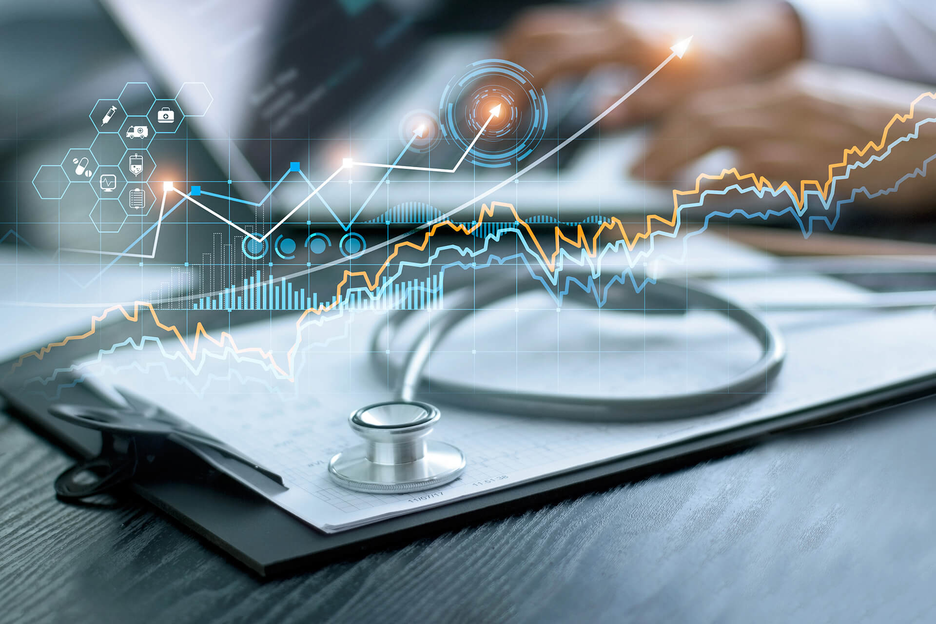 Slider showcasing healthcare with graphs and a person typing on a laptop in the background out of focus